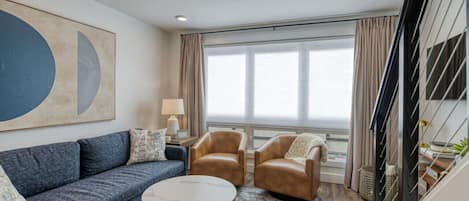 The living room. This room has been stylishly designed and has comfortable seating for 4. There is a smart TV, bookshelf, and coffee table to help support all the relaxing you're looking for.The living room. This room has been stylishly designed and has c