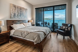 Primary bedroom with floor to ceiling windows and deck access.