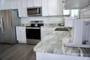 Beautiful open kitchen with new stainless-steel appliances, coffee maker and toaster