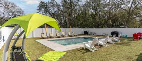 Spacious backyard with pool, sun loungers, fire pit, grill and dining area