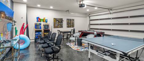large game room filled with ping pong table, air hockey table, 2 freestanding arcade games, complete super Mario brothers switch video game, game chairs and additional game table. Large 65" wall mounted TV, hours of fun for everyone.