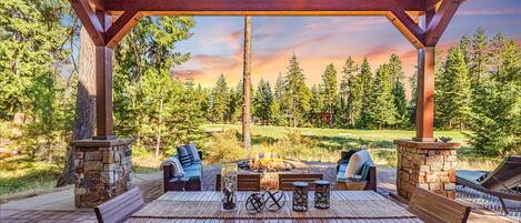 An oasis of relaxation awaits in this high-end mountain home outdoor covered patio that overlooks hole 7 on Rope Rider
