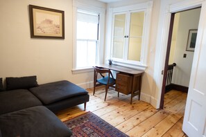 Upstairs dedicated workspace with desk and couch.