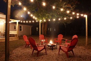 Step into our backyard haven, where the firepit glows and string lights twinkle