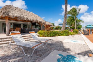 Experience the pinnacle of poolside lounging in luxurious, palm-thatched cabana.