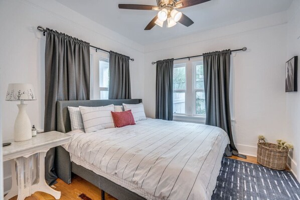 Primary bedroom with king-size bed, new double-pane windows, blackout shades, and large closet