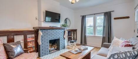 Original hardwood floors, gas fireplace, sleeper sofa, and new smart TV