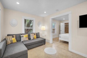 Enjoy the tranquil living and dining zone, complete with a cushy sofa that effortlessly converts into a bed for added relaxation