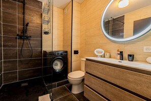 salle d'eau moderne avec douche, WC, machine à laver