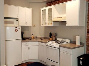 Full kitchen with a Keurig coffee maker and cooking basics.