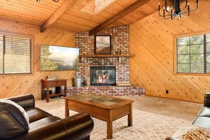 Wood burning fireplace and Smart TV for streaming in the living room space.
