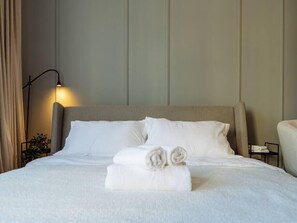 Comfortable queen sized bed with cotton linens and fluffy towels