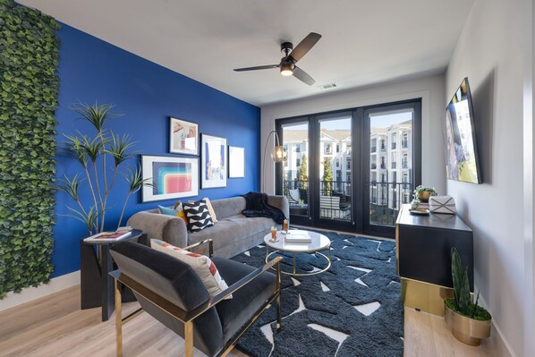 Bright open living space featuring a smart flat-screen TV and designer furnishings.