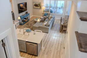 View from stairs of living room and kitchen island.