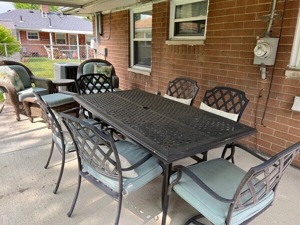 Spacious covered patio with cushioned seating for 8—perfect for outdoor dining, game nights, or sipping morning coffee rain or shine. A relaxing space to gather, unwind, and make lasting memories during your stay.