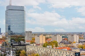 A cityscape view featuring high-rise buildings, residential areas, and a blue sky.
