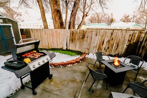 An inviting outdoor table situated near the BBQ grill, perfect for enjoying freshly grilled meals in the beauty of the outdoors.