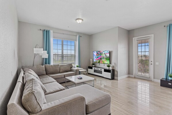 Relax and Unwind: This Living Room Welcomes You with a TV, Comfortable Couch, and Accent Chairs, Adorned with Decoratives for Added Charm and Comfort.