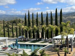 Embrace tranquility where azure waters meet majestic mountains; a paradise touched by the whispers of palm and cypress trees. This isn't just a saltwater pool, it's a serene escape into nature's luxury lounge.