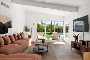 Mid-century decorated living rom equipped with a TV to stay up to date with all your favorite shows!