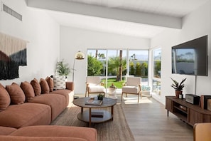 Mid-century decorated living rom equipped with a TV to stay up to date with all your favorite shows!