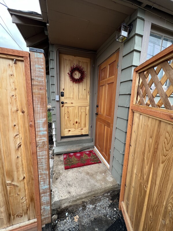 Entrance to cottage, fully fenced and gated. Laundry room is also pictured.