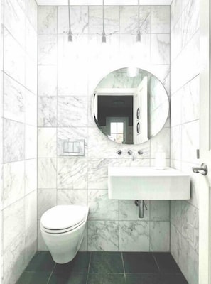 Luxurious first floor half bath with marble walls, in wall toilet, slate floors