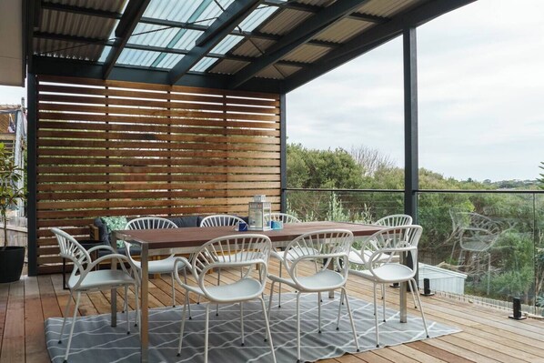 A generous undercover deck offers a peaceful space to grill and dine alfresco at the eight-seater table while enjoying views overlooking the surrounding greenery. 
