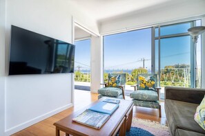A cosy living area offers the perfect retreat to kick back with some TV or settle in with your favourite book, with floor-to-ceiling windows capturing views overlooking the bay. 
