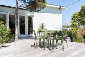 The front entrance features a balcony with a four-seater setting where guests can dine alfresco, surrounded by beautiful gardens. 