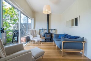 The cosy living area features a sofa and armchairs where guests can settle in with a movie after a day of sightseeing. 
