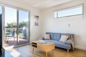 Gather with your group in the living area, offering easy balcony access for shared moments and relaxation.