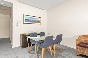 Enjoy a home cooked meal at the glass dining table connected to the living area.