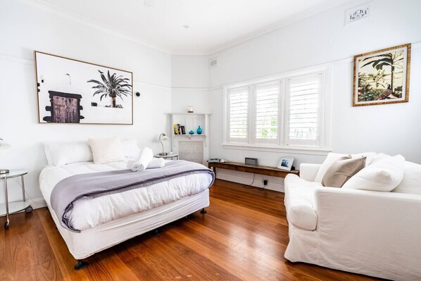 The spacious bedroom highlights a queen-size bed and has a plush seating area for getting ready.