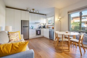  The light-filled living and dining area includes a four-seater table to enjoy home-cooked meals. 

