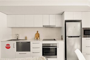 This modern kitchen comes complete with appliances, including a pour-over coffee setup – perfect for those mornings. Plus, you'll appreciate the ample storage for all your culinary needs.