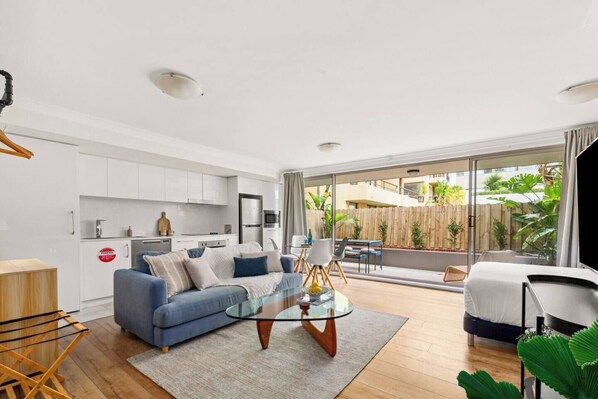 The living area offers garden views from the balcony. Floor-to-ceiling windows invite fresh air and breezy ambiance.