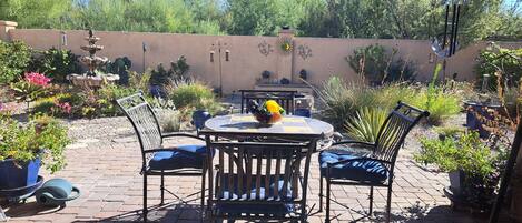 View from living room into backyard garden with water fountain.