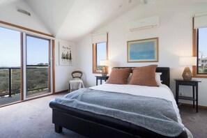 Sleep easy within the primary bedroom. It highlights a queen-sized bed and beautiful views.