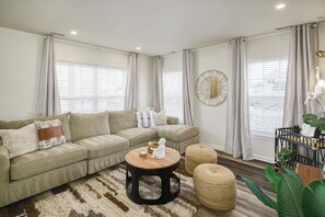 The living room features a large sleeper sectional with tons of seating for your group