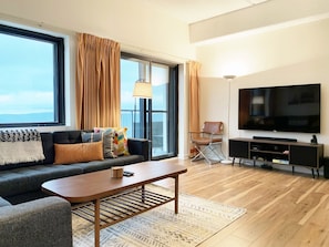 Mid-century modern inspired living room with 65" smart Rooku TV.
