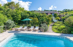 Expansive terrace, pool, lounge chairs facing the panoramic views. Gazebo with dining table next to the pool.