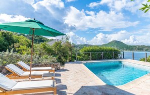 Expansive terrace, pool, lounge chairs facing the panoramic views. Gazebo with dining table next to the pool.