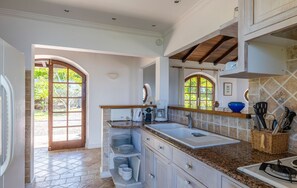 Fully equipped air conditioned kitchen, with electric oven, microwave, fridge and freezer, dishwasher, toaster, coffee machine, blender, electric kettle. Outside dining areas with a rectangular table for 6 guests on the terrace, and a wooden table under t