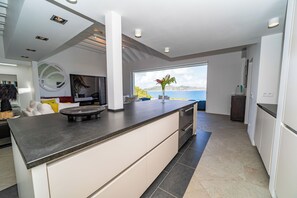 Fully equipped kitchen with a central island, four stools. Refrigerator, freezer, oven, blender, filter coffee maker and Nespresso coffee machine, toaster.