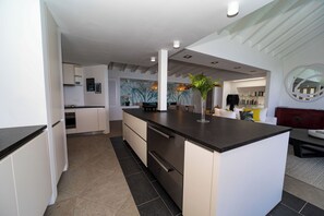 Fully equipped kitchen with a central island, four stools. Refrigerator, freezer, oven, blender, filter coffee maker and Nespresso coffee machine, toaster.