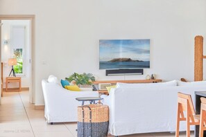 HD-TV avec satellite américain et Apple TV, grands canapés, ventilateurs.