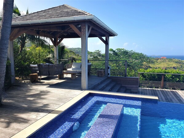 Nice lounge on the covered terrace and under an ajoupa. Outdoor wooden dining table for 8 people.