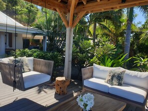 Nice lounge on the covered terrace and under an ajoupa. Outdoor wooden dining table for 8 people. 
