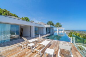 Expansive terrace with deck loungers, long heated pool facing the panoramic views. Outdoor lounge area under the gazebo.